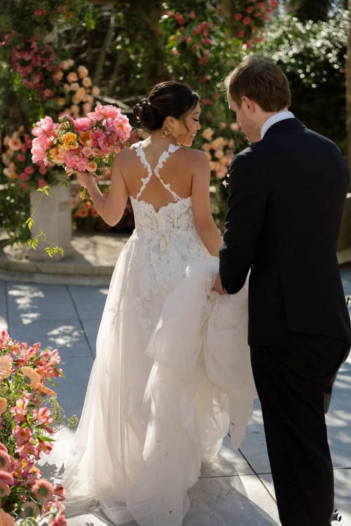 Bride holding a lush bridal bouquet of fresh tulips and seasonal florals by Intrigue Designs at Crystal Plaza wedding.